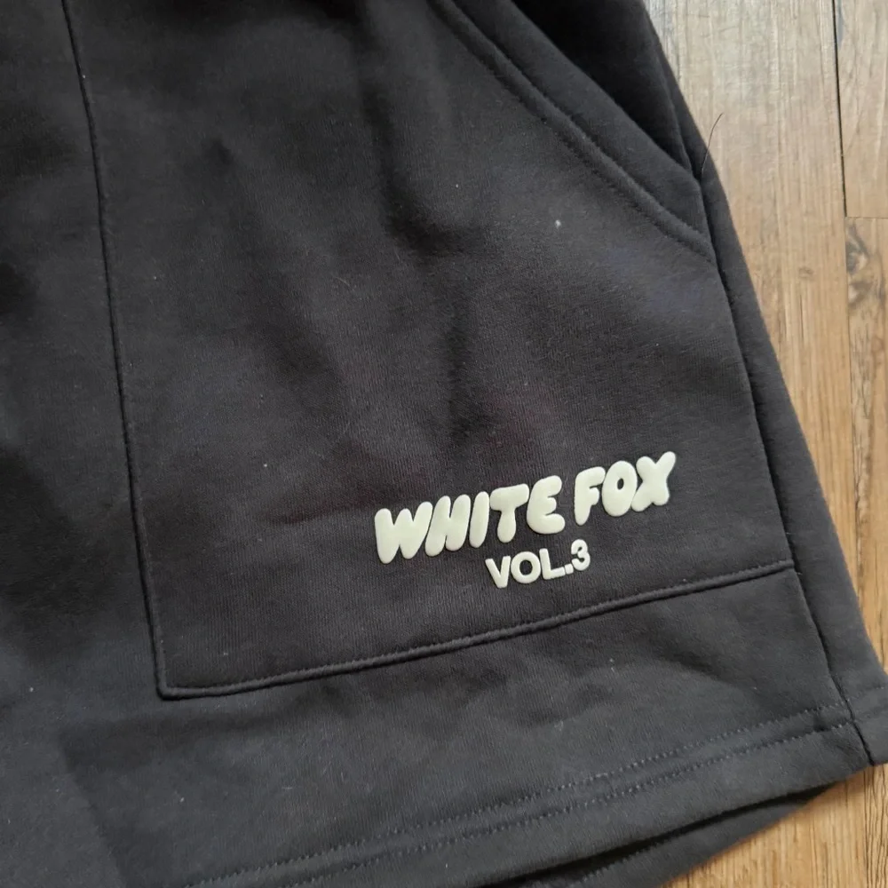 White Fox Boutique charcoal shorts with white text reading 'WHITE FOX VOL.3'